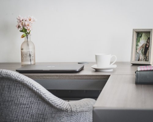 Woman stretching arms at office desk gently